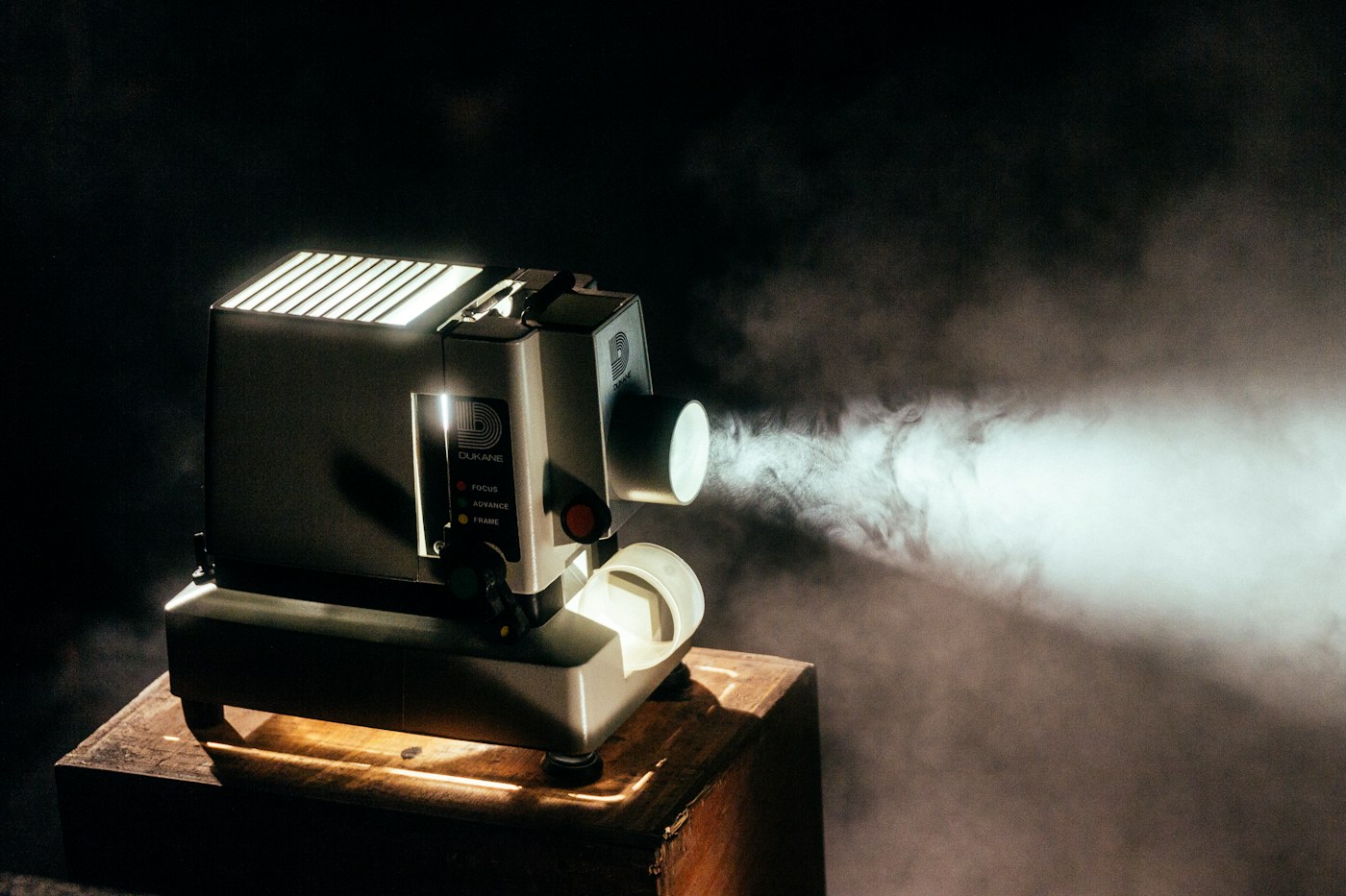 A vintage film projector casting light across a dark room
